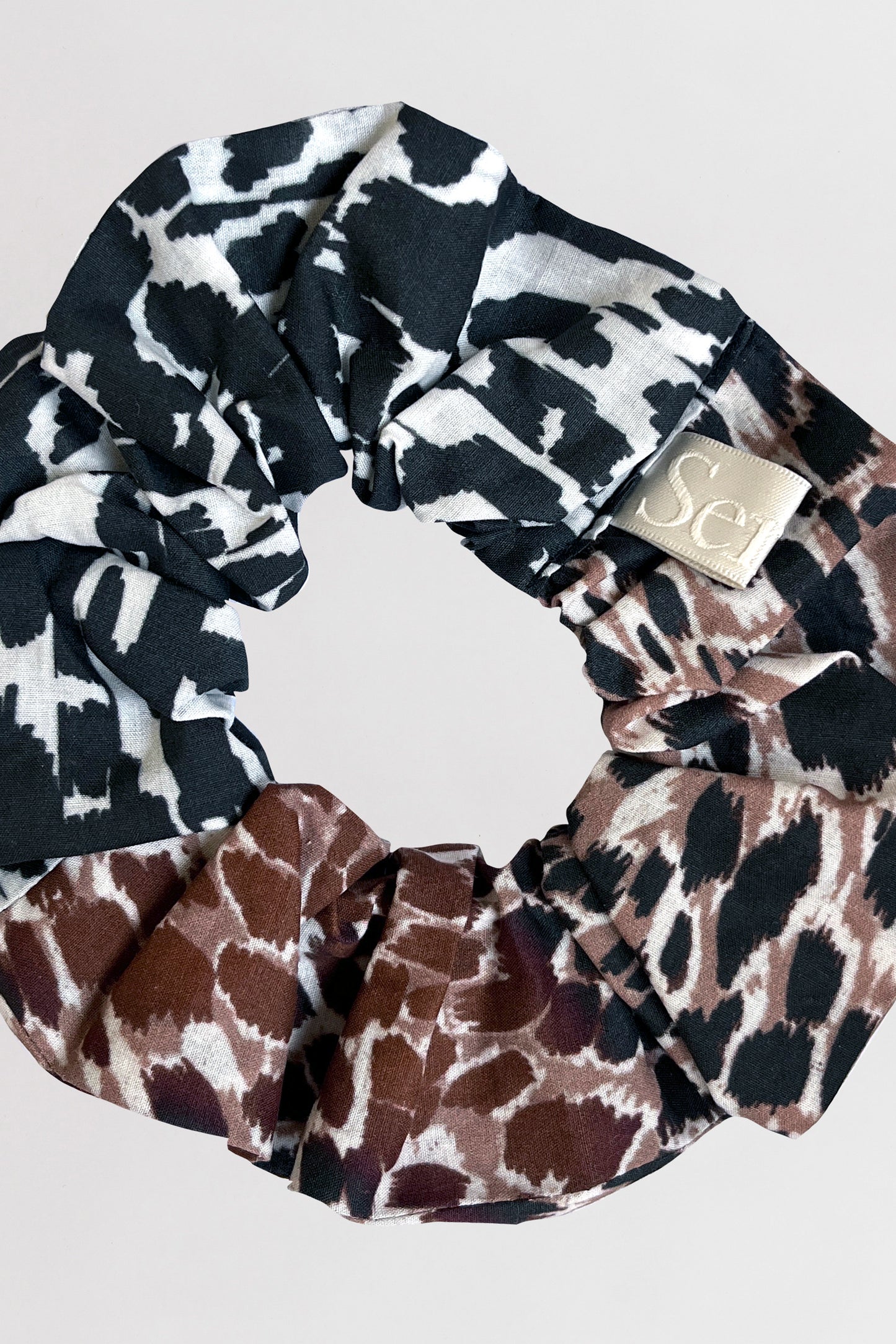 Close-up of animal printed scrunchie crafted from 100% organic cotton on a neutral background.
