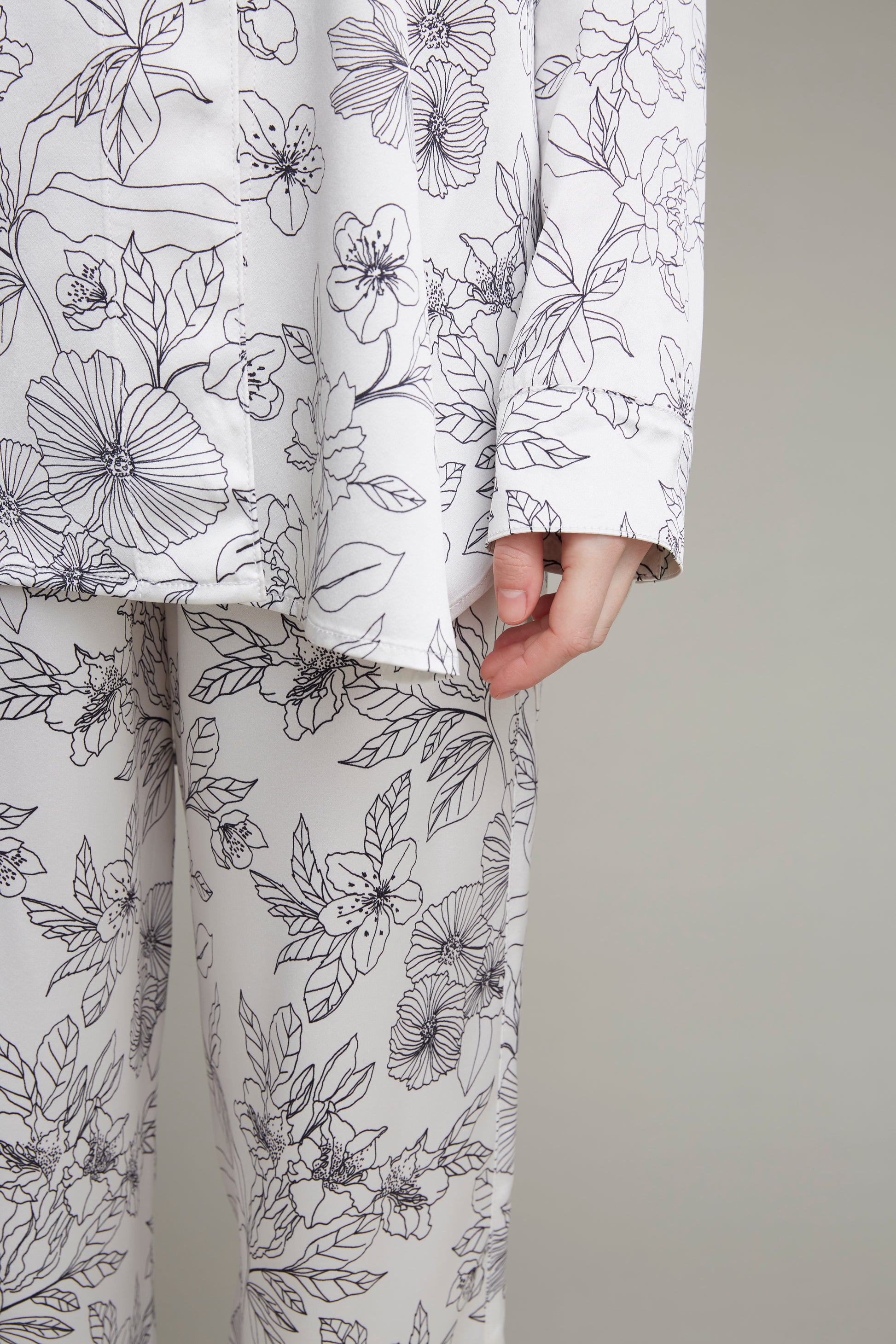 Close-up view of white floral-print loungewear pajama set for women, showcasing intricate details of the shirt and pants.